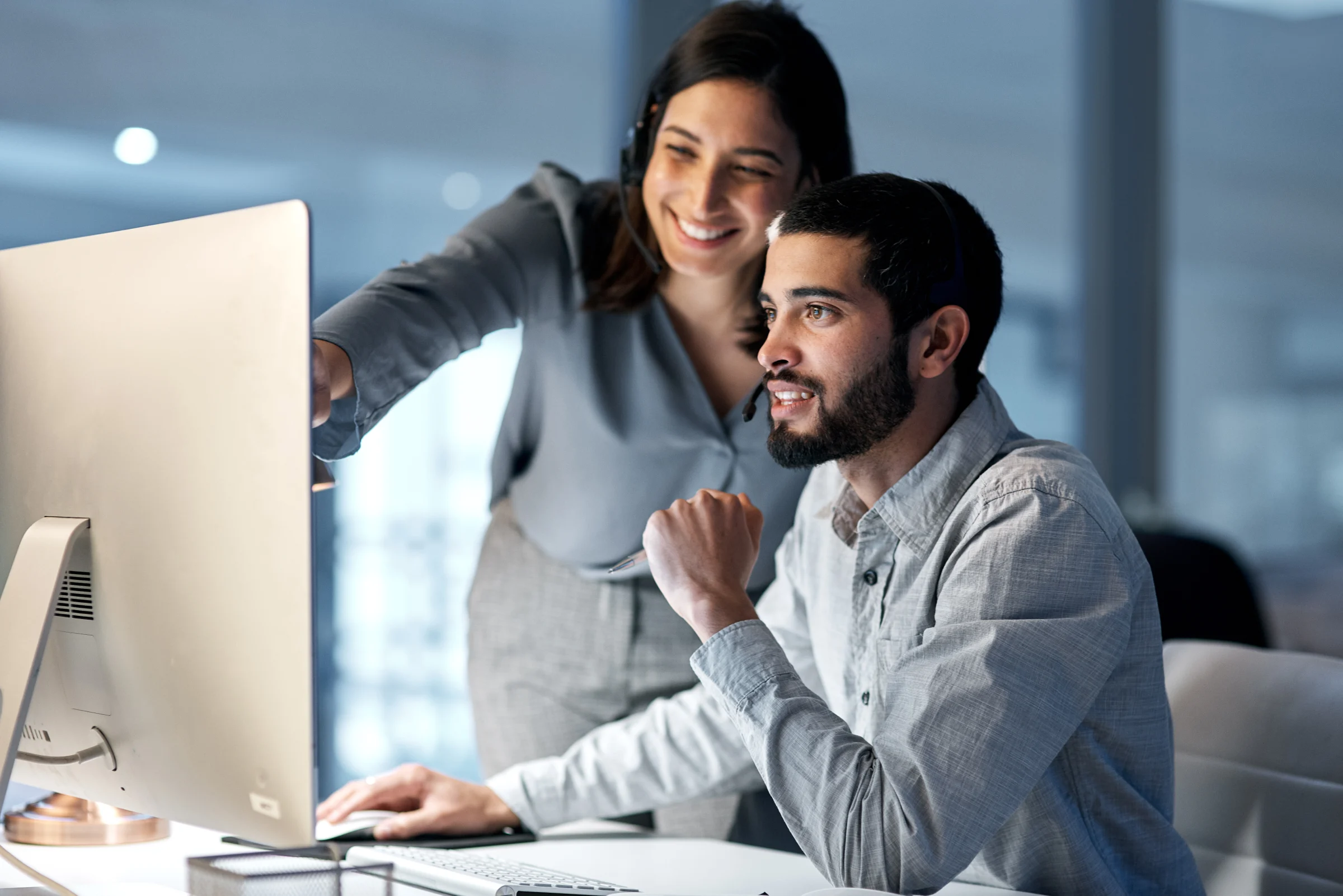 Support team collaborating at a desktop computer.