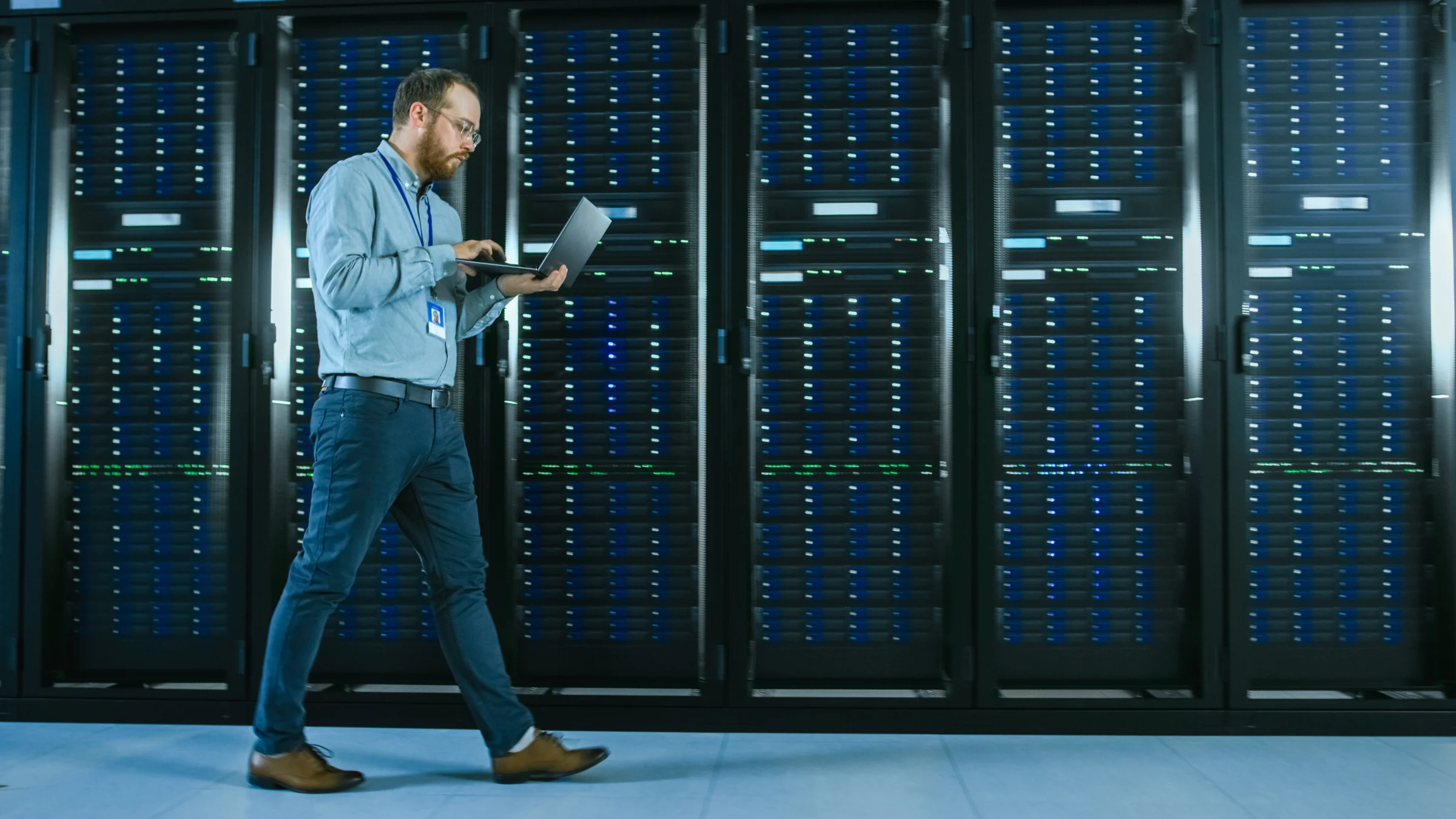 Technician checking server racks with a tablet.