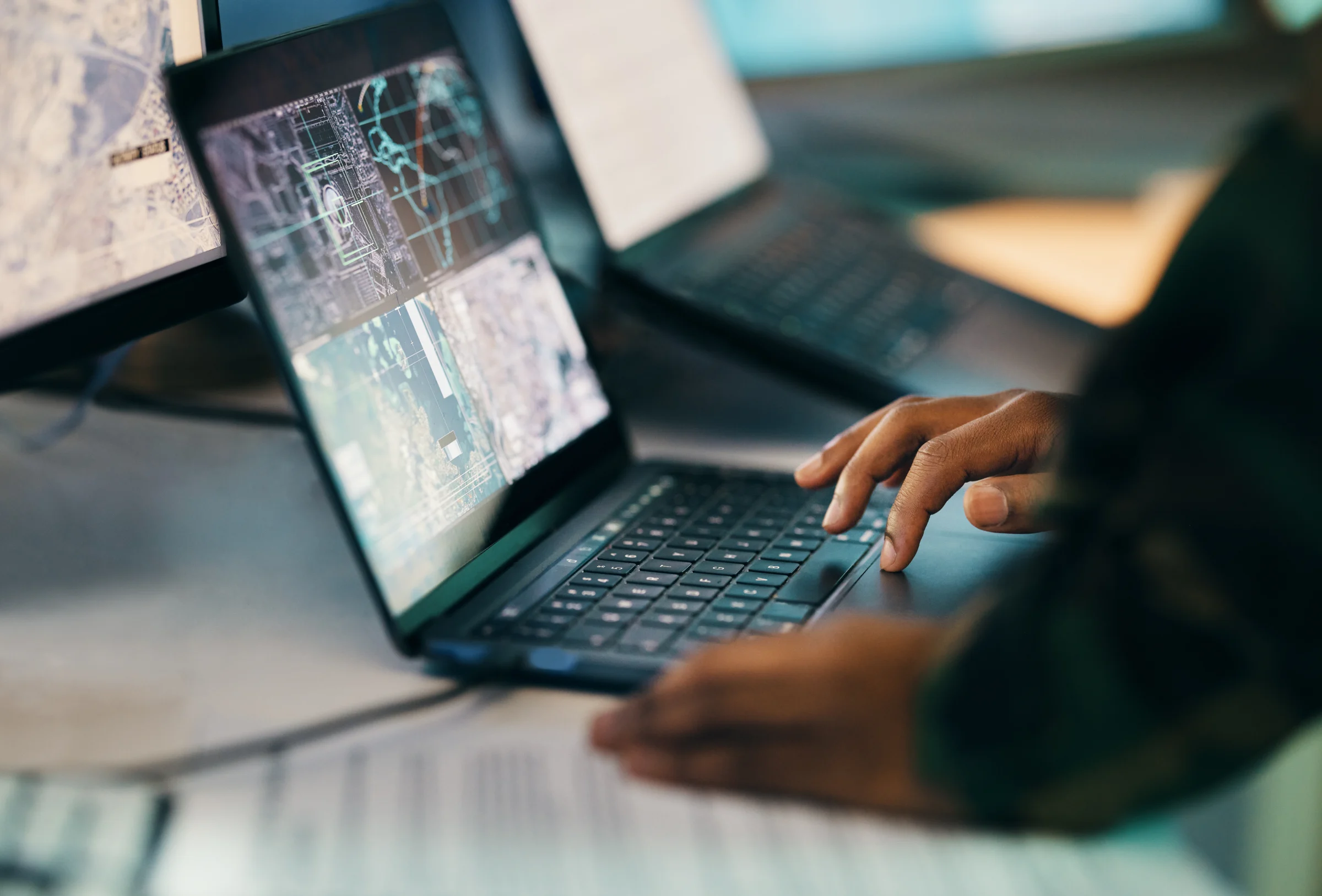 Professional working on a laptop beside a second computer.