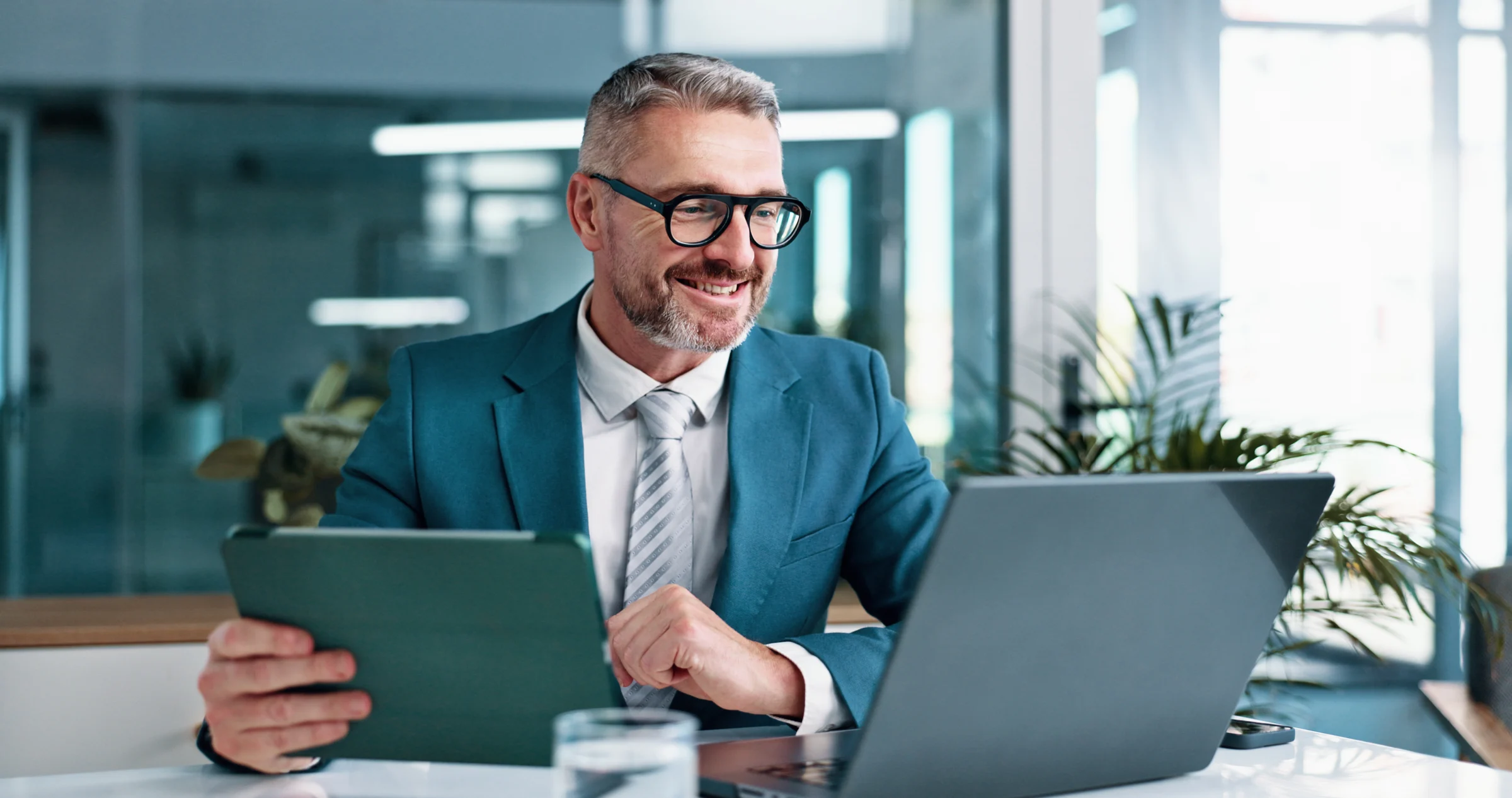 Business professional using a laptop and tablet.